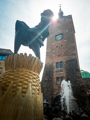 white tower of nuremberg with fountain sculpture