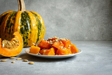 Traditional Turkish Pumpkin Dessert with sherbet on rustic table and fresh sliced pumpkins