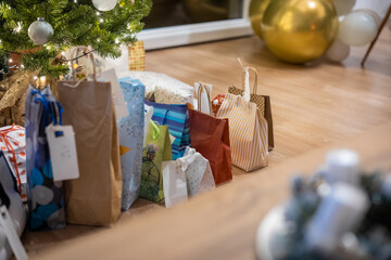 A bunch of christmas presents piled under a tree at this special day. Family gathering and presenting gifts.
