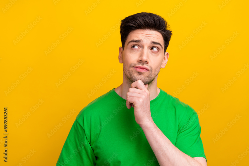 Sticker Portrait of young businessman touch chin looking empty space see his uncompleted old job he should do isolated on yellow color background