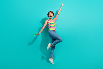 Obraz premium Full size photo of astonished positive girl raise hands rejoice have good mood isolated on teal color background