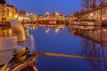 Night Leiden canal with Blauwpoortsbrug bridge and Windmill De Valk, South Holland, Netherlands.