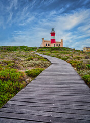 Fototapeta na wymiar Cape Agulhas Lighthouse, southernmost tip of Africa with woodem walkways, L'Agulhas, South Africa