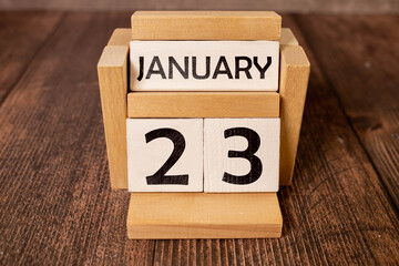 January 23rd.January 23 white wooden calendar on wood background. Copyspace for your text.