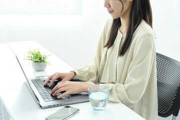 ノートパソコンで作業する若いアジア人女性