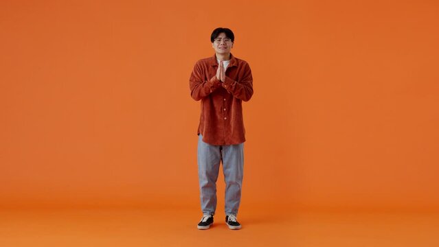 Asian guy pleading with hands together and getting desired