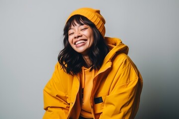 Portrait of a beautiful asian woman in yellow raincoat laughing