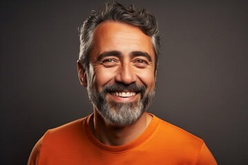 Portrait of a smiling middle-aged man in orange t-shirt.