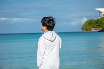 広い海を見つめる少年　A boy staring at the wide ocean