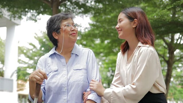 Happy Asian family concept. Elderly mother and happy smiling daughter in outdoor garden. Elderly caregiver in a health center