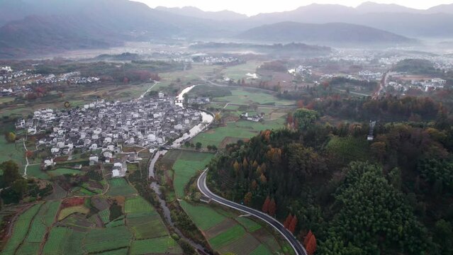Aerial view of Chinese ancient village, Lucun, Hongcun, Anhui, China. Drone fly view of traditional villages in sunny autumn morning, sunrise time, colorful autumn forest, 4k real time footage.