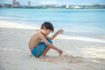 Fototapeta na wymiar 海で遊ぶ男の子　boy playing in the sea