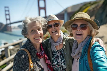 Fotobehang Three smiling female senior tourists visiting San Francisco posing looking at the camera © Adriana