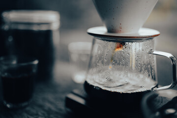 Men barista making a drip coffee, pouring hot water from kettle over a ground coffee powder