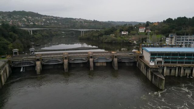 Frontal wide angle view of Velle water dam and power plant in Ourense, Galicia, Spain and bridge reflection