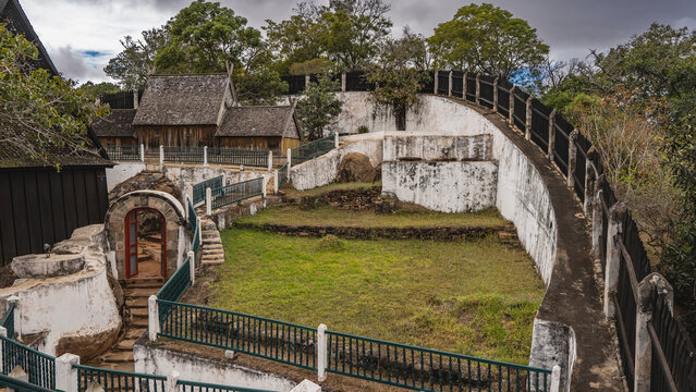 The ancient palace on the Royal Hill of Ambohimanga in Antananarivo. On the fenced territory, old wooden tombs with the remains of the rulers of Imerina are visible. Green grass on the lawn.Madagascar
