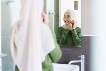 Muslim woman looking herself in a mirror.