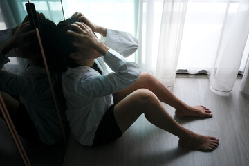 woman sitting in the corner of the room have emotional and mental problems She has depression and...