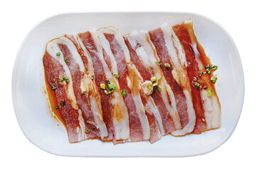 Raw pork slice for barbecue japanese style, yakiniku, pork are being cooked on stove served on white dish in Japanese restaurant.