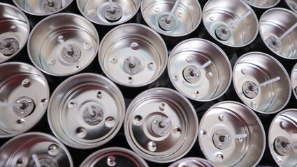 Tealight holder tops of multiple aluminum cans, likely from beverages. These can tops are shiny and...