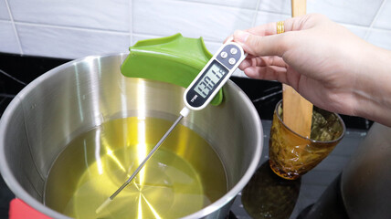  5-soy wax melting tempesoy wax melting temperature person using a digital thermometer to measure...