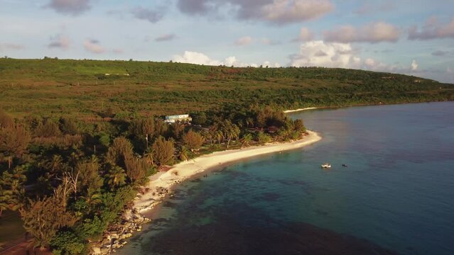 Pan aerial shot of Taga beach during a golden hour