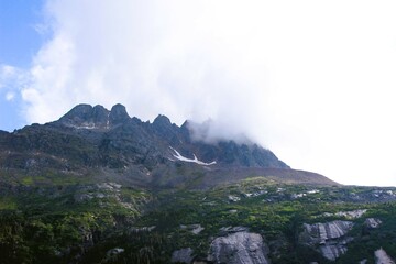 Clouds hanging over the top of a rugged mountain in Southern Alaska