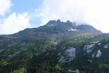 Clouds hanging over the top of rugged mountains in Southern Alaska