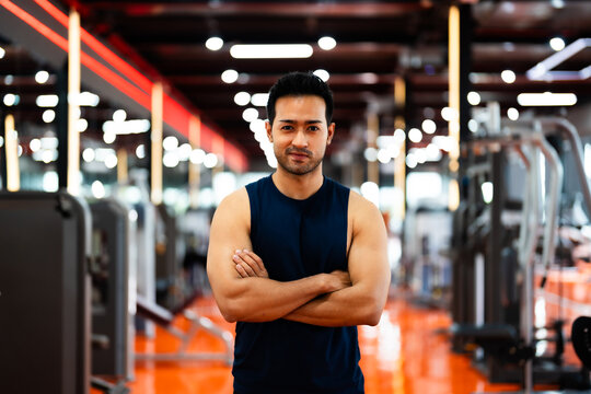 Energetic Fitness Sportsman at Gym. Asian Man Athlete Crosses Arms. Handsome Guy Smart and Confidence in Fitness Center