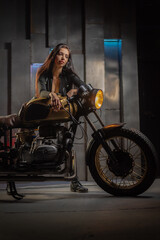 Young beautiful girl with dark hair on the old motorbike. Girl motorbiker.