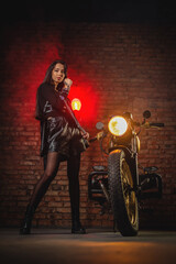 Obraz na płótnie Canvas Young beautiful girl with dark hair on the old motorbike. Girl motorbiker.
