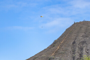 Fototapeta na wymiar Helicopter evacuate a tourist hiker from the top of Coco head trail, Hawaii, Oahu