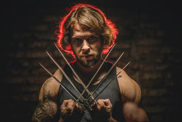 Man with iron claws on the dark background. Werewolf concept. - obrazy, fototapety, plakaty