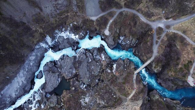 Stunning wild blue river and waterfall Barnafoss in volcanic landscape, aerial top down panorama