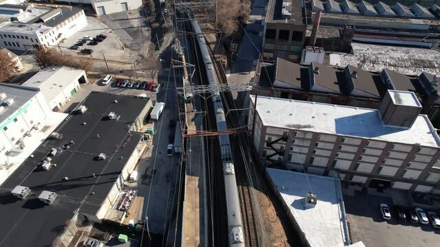amtrak acela departing pan up drone over tracks sunny winter day wilmington delaware biden station 