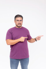 A smart middle aged man pointing something to the right with both fingers. Wearing a purple waffle shirt and jeans. Full body photo, isolated on a white background.