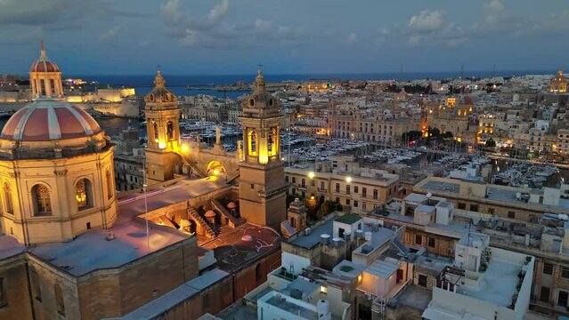 Aerial shot of evening Malta. Flying around church in Senglea  and view to three cities and marina with yacht in Malta