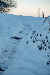 footpath in snow leading up to hill