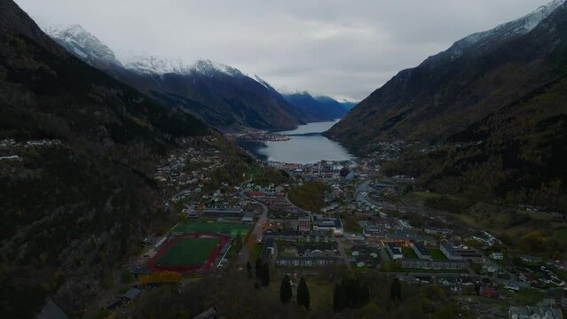 aerial view of city of odda during morning during morning in norway with lakes and mountains on background