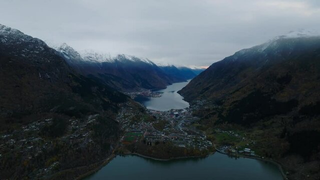 aerial view of city of odda during morning during morning in norway with lakes and mountains on background