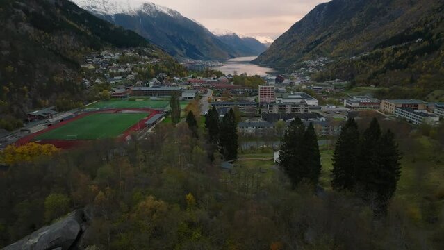 aerial view of city of odda during morning during morning in norway with lakes and mountains on background