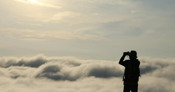 Silhouettes of tourists taking pictures of beautiful landscapes and fog.