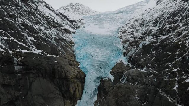aerial close up view of tongue of briksdalsbreen glacier blue ice on top of mountain in norway