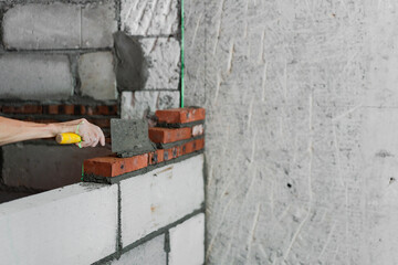 Close-up of the hands of a construction worker building a wall.