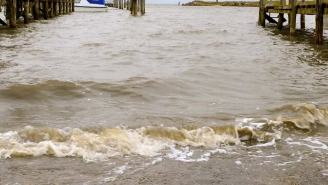 Close -up of waves hitting the pier of a small harbor in Rantum, Sylt.