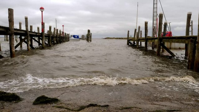 Waves hitting the pier of a small harbor in Rantum, Sylt.