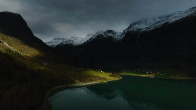 aerial view on norwegian fairytale scenic view with house on shore in sun light of Oldevatnet lake with mountains reflecting in water in norway