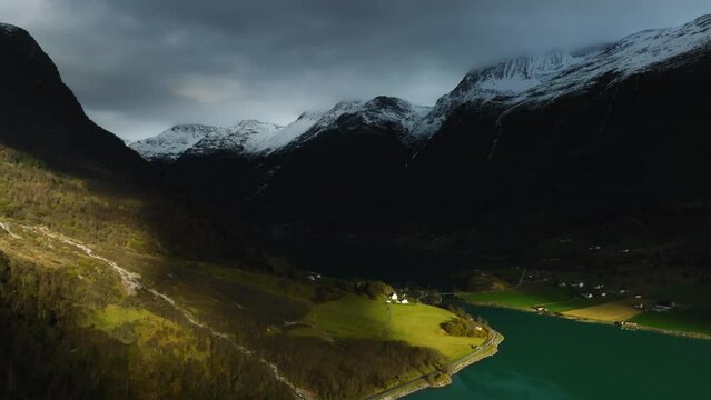 aerial view on norwegian fairytale scenic view with house on shore in sun light of Oldevatnet lake with mountains reflecting in water in norway