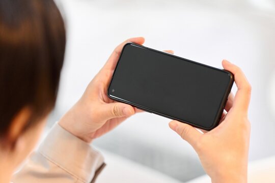 スマートフォンで動画を見る女性