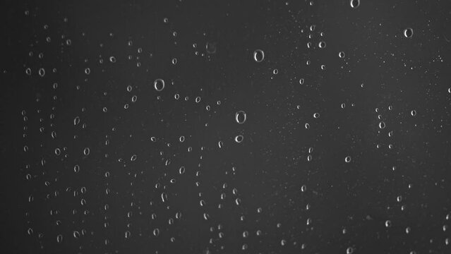 Close-up of glass wall of shower with water drops way down with defocus background. Movie shot December 25th, 2023, Zurich, Switzerland.